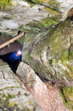 A spelunker wearing a headlamp looks up from inside a cave at Warsaw Caves Conservation Area