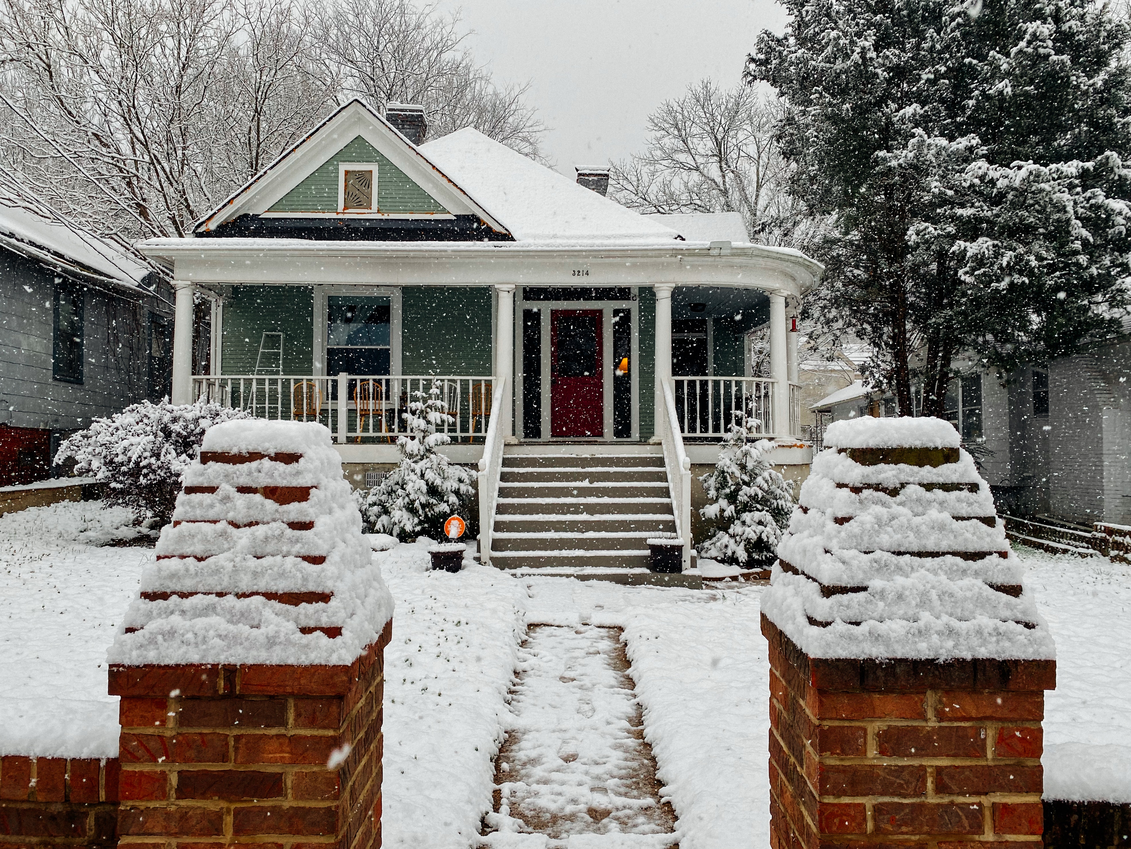 snowy walkway at residential home with snow falling and winter conditions.