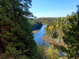 The view from the top of the Lookout Trail at Warsaw Caves Conservation Area with the Indian River flowing by far below, surrounded by forests.